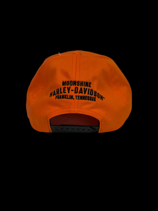 An orange snapback cap shown from the back, featuring black embroidered text that reads 'MOONSHINE HARLEY-DAVIDSON FRANKLIN, TENNESSEE' on a light gray background.